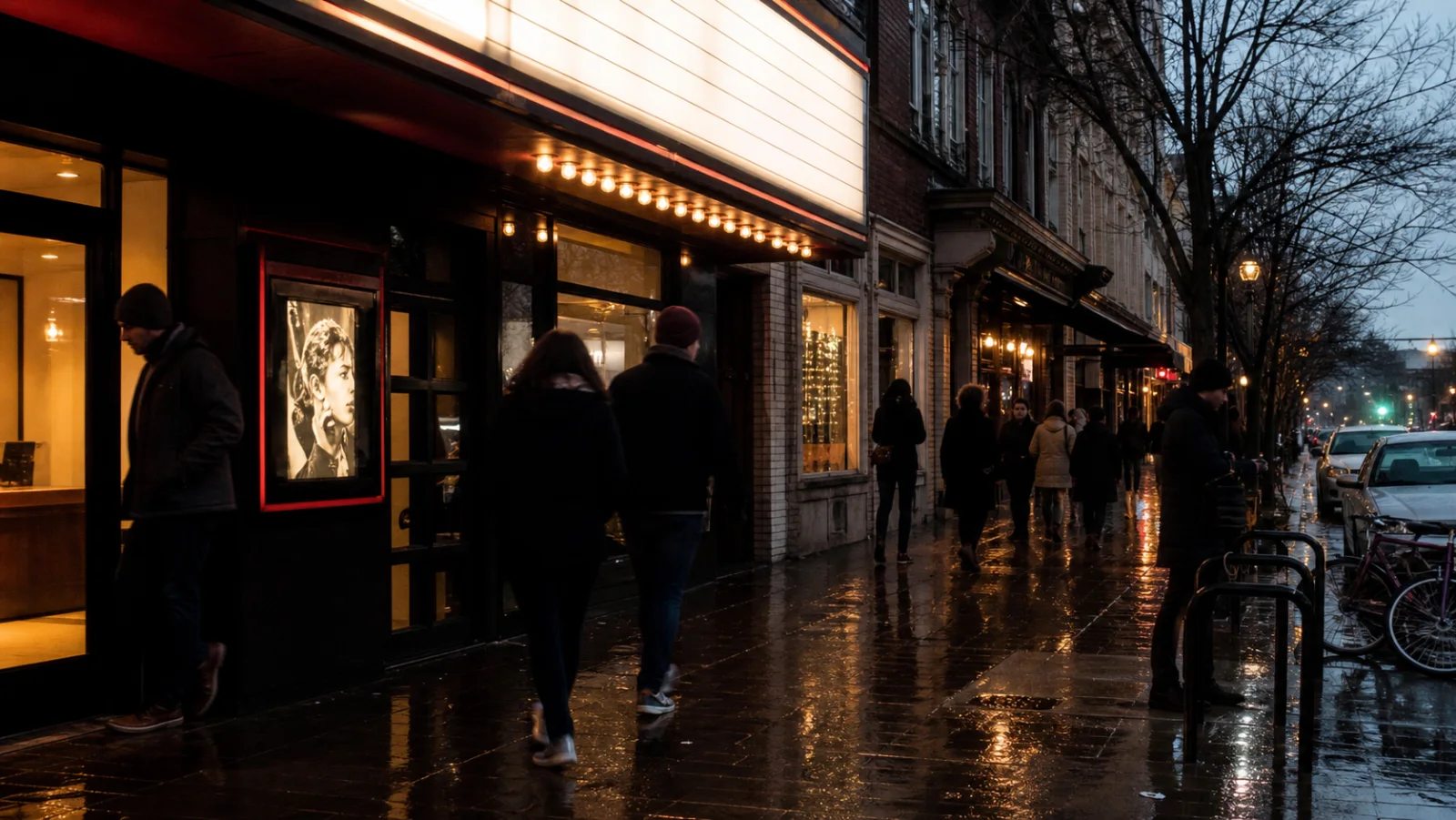 Portland neighborhood storefronts and a cinema on a wet evening