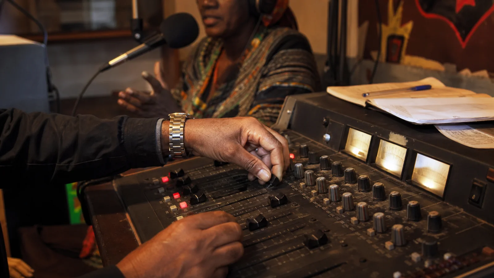 Close view of a community radio mixing console during a cultural interview