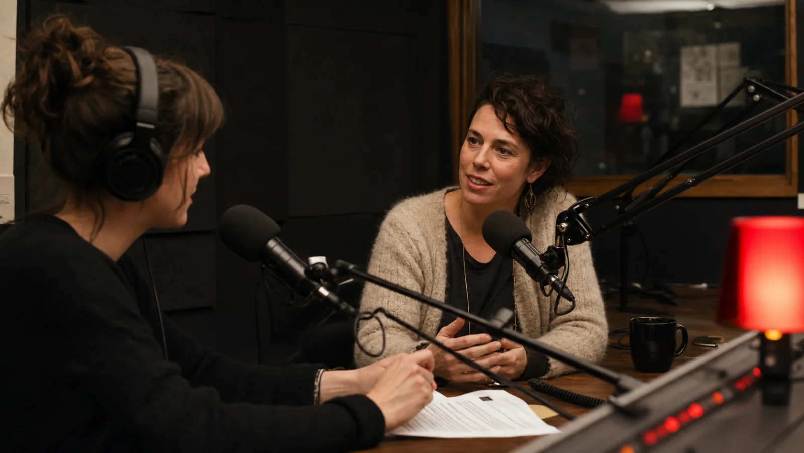 Community radio host interviewing a film festival organizer in a warm studio